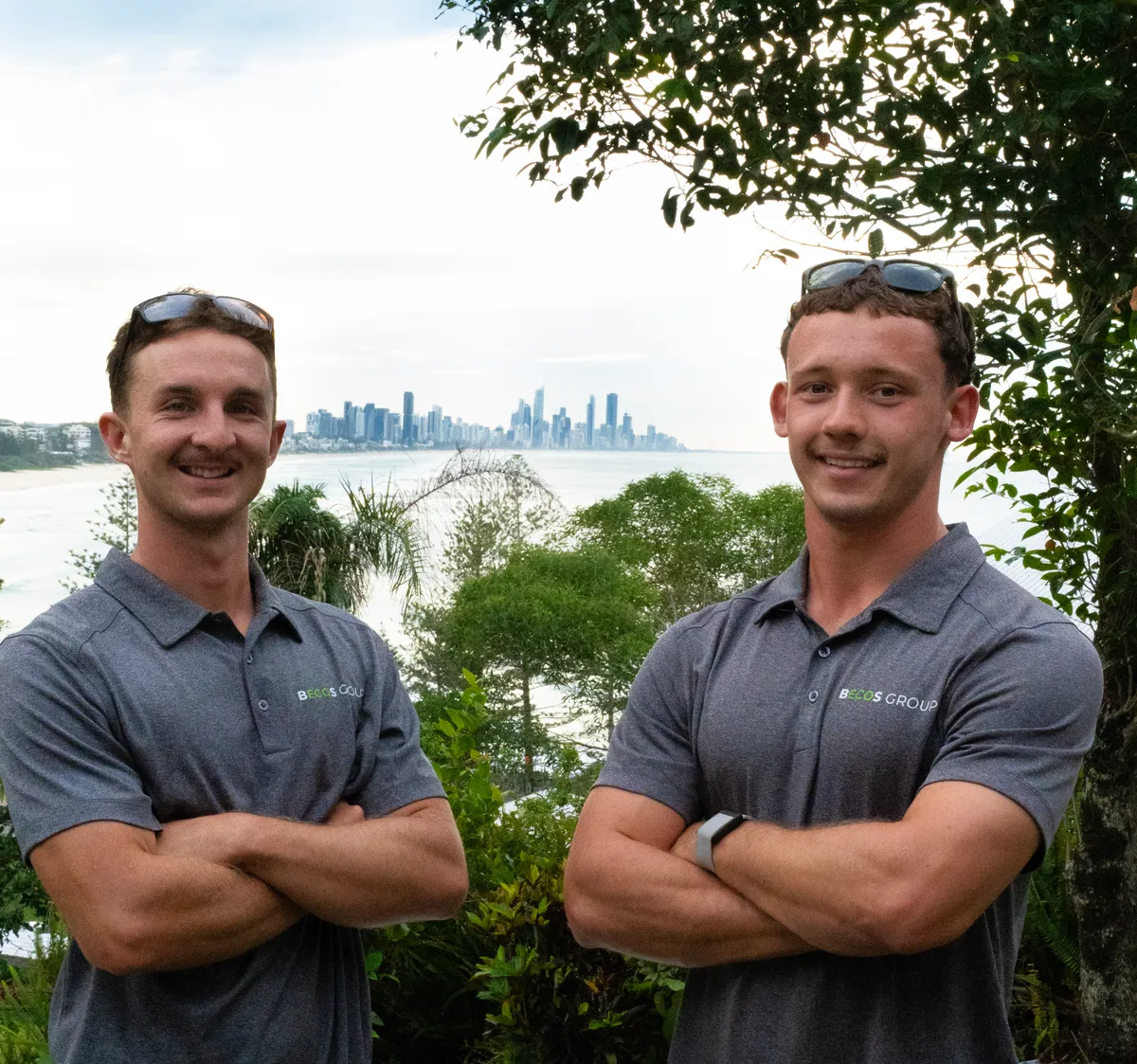 Becos Group co-owners Ollie and Sam at a coastal job site with the Gold Coast skyline behind them
